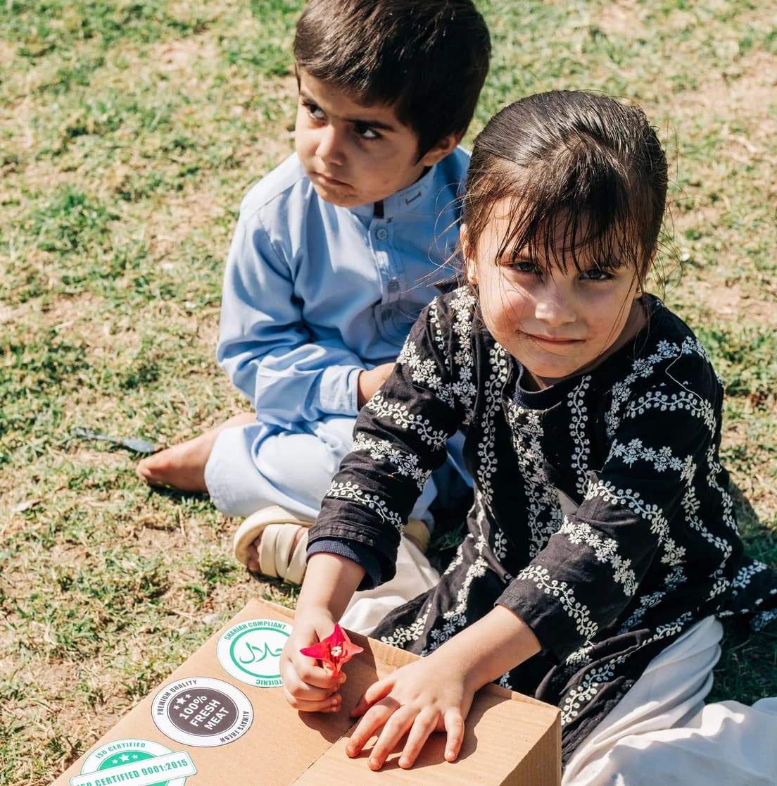 Two children beside a branded Shukar Hai dawat box