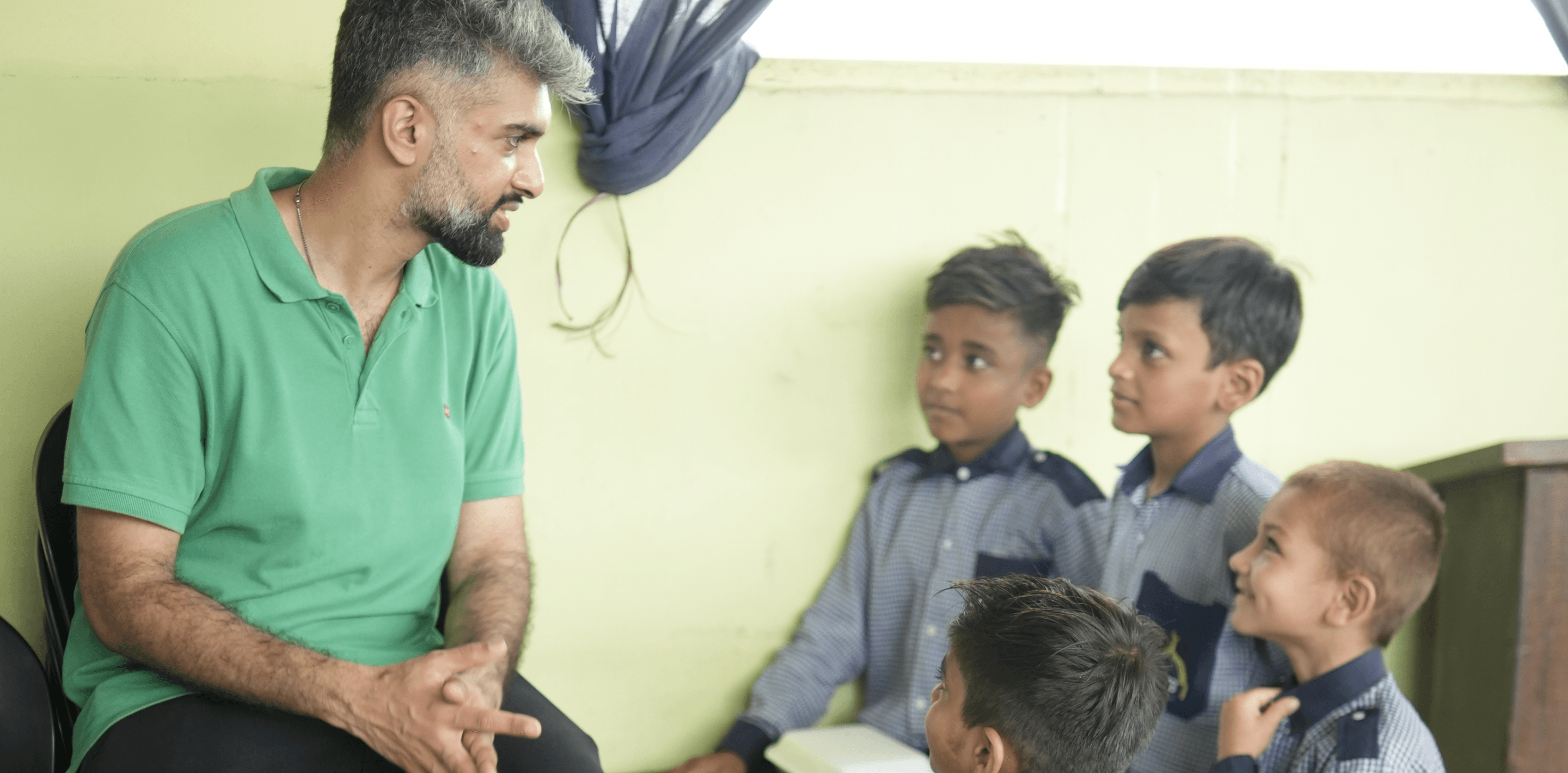 The founder sitting and sharing a meal with children